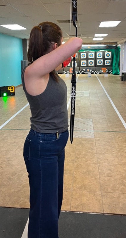 Marissa drawing a recurve bow at the indoor range