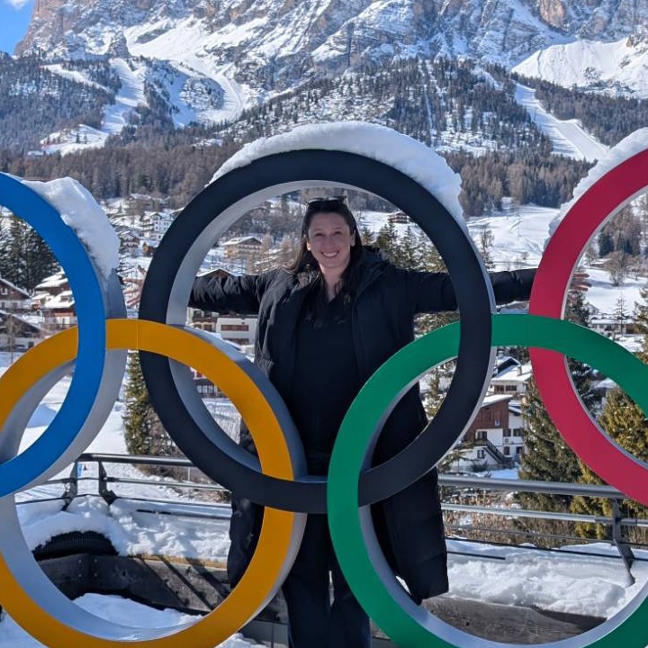 Marissa Clark standing in the Olympic rings in Cortina